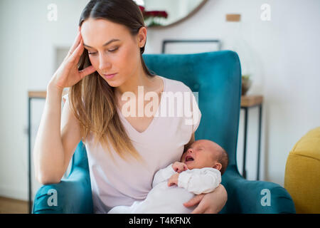 Betonte Mutter Holding Baby Schreien von postnatalen Depressionen leiden zu Hause Stockfoto