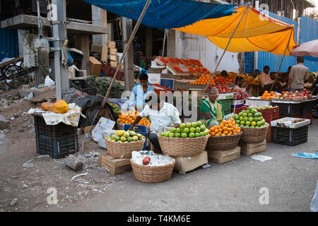 Obst Anbieter für Kunden auf dem Straßenrand von einer geschäftigen Straße mit Moazzam Jahi Markt in Hyderabad, Indien. 13. April 2019 Stockfoto