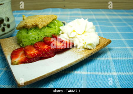 Pandan klebriger Reis thailändische Vanillesauce mit Kokosmilch mit Erdbeeren und Sahne serviert, thailändisches Dessert Asian Food Styling. Stockfoto