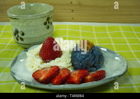 Blauen Erbse klebriger Reis Hackfleisch Fisch mit Kokosmilch mit Erdbeeren und Sahne serviert, thailändisches Dessert Asian Food Styling. Stockfoto