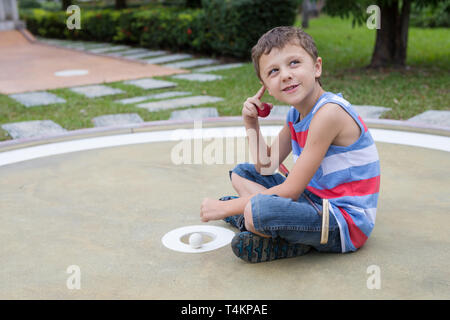 Happy little boy spielen Minigolf spielen Minigolf in einem Park am Tag Zeit. Kind Spaß otdoors. Konzept der guten Freizeitaktivitäten. Stockfoto