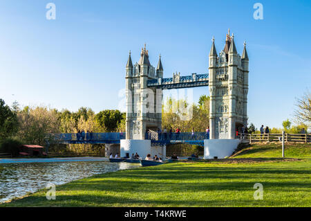 Madrid, Spanien - 15 April, 2019: Vervielfältigung der Tower Bridge in London im Europa Park von Torrejon de Ardoz. Besucher segeln in Boote an sonnigen Stockfoto
