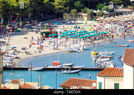Strand der Côte d'Azur mit Touristen mit Sonnenliegen und Sonnenschirmen auf den heißen Sommer Tag Stockfoto