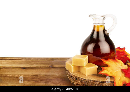 Ahorn Sirup Flasche auf einem Holzbrett, auf weißem Hintergrund. Kopieren Sie Platz für Ihren Text. Stockfoto