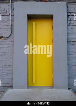 Leuchtend gelb metallic Tür in graue Wand. Eingang City Cafe Stockfoto