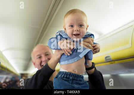 Vater steht mit seinen sechs Monate alten Baby im Flugzeug Stockfoto