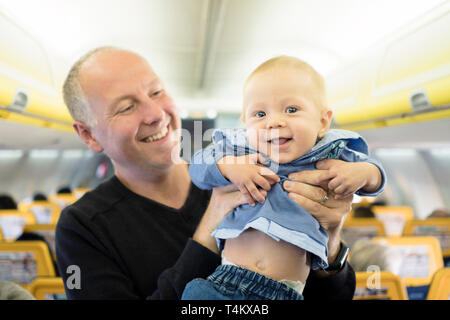 Vater steht mit seinen sechs Monate alten Baby im Flugzeug Stockfoto