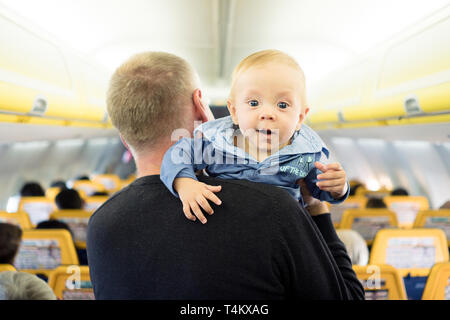 Vater steht mit seinen sechs Monate alten Baby im Flugzeug Stockfoto