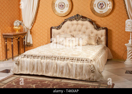 Leere Innenbereich Schlafzimmer Hintergrund in warmen Farben gehalten und mit klassischen und luxuriösen Möbeln eingerichtet Stockfoto