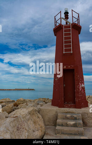 Denia, Alicante, Spanien, 21. November 2018: rote Leuchtturm Eingang zum Hafen von Denia, grün Leuchtturm im Hintergrund Stockfoto