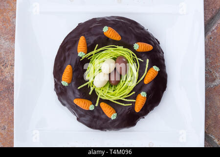 Detail von Ostern Schokolade Kuchen mit Nest und süße Eier in weißen Hintergrund. Stockfoto