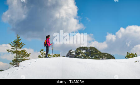 Lonely Girl Spaziergänge in den Bergen im Schnee Stockfoto