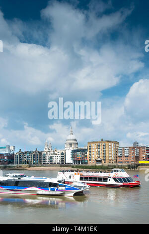 Ein Fluss Thames Clipper City Cruises Boot und einem Schiff auf der Themse mit der Kuppel der St. Pauls Kathedrale im Hintergrund. Stockfoto