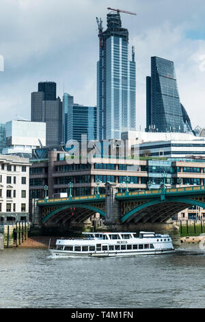 Die touristische Sehenswürdigkeiten boot Mercia vorbei unter die Southwark Bridge über die Themse mit der ikonischen Hochhäusern im Hintergrund. Stockfoto