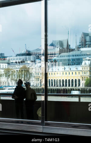 Die verzerrte Reflexionen von Gebäuden auf dem Damm in großen Glasfenstern in einem Gebäude auf dem South Bank in London gesehen. Stockfoto