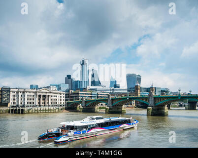 Ein Thames Clipper Schifffahrt auf der Themse nähert sich die Southwark Bridge in London. Stockfoto