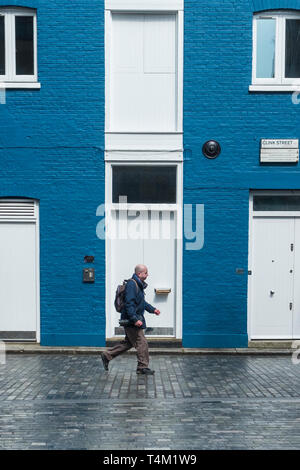 Ein Mann der Vergangenheit wandern Ein Haus blau lackiert und Weiß in den Knast Street in London. Stockfoto