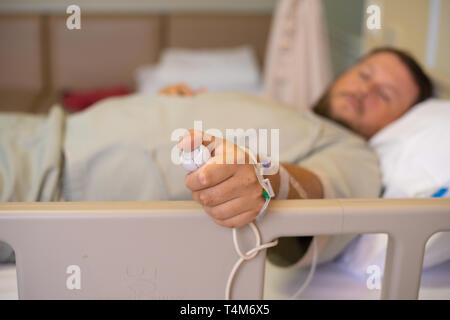 Mann in einem Krankenhaus als Krankenschwester. Eine Hand mit Not-Aus-Knopf im Krankenhaus Zimmer. Not-Aus-Taster für Patienten im Krankenhaus Stockfoto