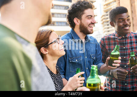 Sind eine Gruppe von Freunden feiern eine Party zusammen und trinken Bier auf dem Hausdach Stockfoto