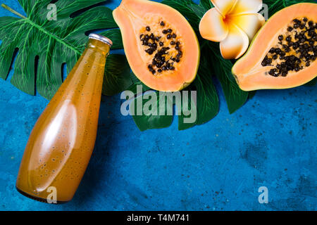 Sommer tropischen Hintergrund mit exotischen Saft papaya mit Chia Samen, grünen Palmen Blätter auf Blau. Obst Hintergrund und im Sommer trinken. Ansicht von oben, kopieren Spa Stockfoto