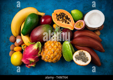 Sommer tropischen Hintergrund mit exotischen verschiedene Früchte auf Blau. Obst Hintergrund. Ansicht von oben Stockfoto