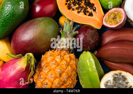 Sommer tropischen Hintergrund mit exotischen verschiedene Früchte Nahaufnahme. Obst Hintergrund. Ansicht von oben Stockfoto