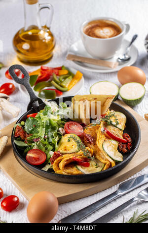 Omelett mit Gemüse mit Cherry Tomaten und Salat serviert. Stockfoto