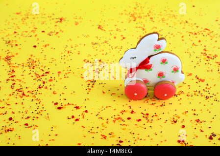 Ostern Konzept, handgefertigte rosa und weißen Bunny Lebkuchen auf einem gelben Hintergrund. Lebkuchen Kaninchen im Frühjahr Stockfoto