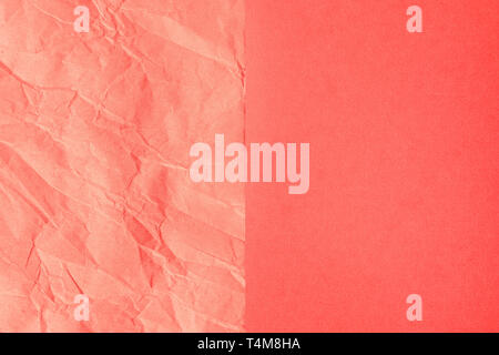 Trendy Coral farbigen strukturierten Hintergrund. Zerknitterte orange-rosa Handwerk Papier und Normalpapier Blätter in der Mitte der Partition erstellen Linie unterteilt. Flach. Stockfoto
