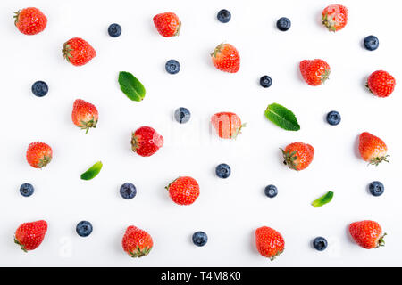 Erdbeere, Heidelbeere und Minze auf weißem Hintergrund, Ansicht von oben. Beeren Muster, flach. Erdbeere, Heidelbeere, Minze isoliert auf weißem b Stockfoto