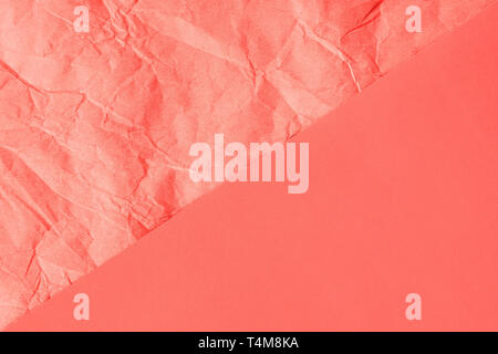 Trendy Coral farbigen strukturierten Hintergrund. Zerknitterte orange-rosa Handwerk Papier und Normalpapier Blatt diagonal geteilt erstellen Linie Partition. Flach. Stockfoto