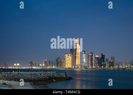 ABU DHABI, VEREINIGTE ARABISCHE EMIRATE - 4. April 2019: Die Stadt von Abu Dhabi in der Abenddämmerung über dem Arabischen Golf gesehen. (Ryan Carter) Stockfoto