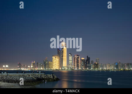 ABU DHABI, VEREINIGTE ARABISCHE EMIRATE - 4. April 2019: Die Stadt von Abu Dhabi in der Abenddämmerung über dem Arabischen Golf gesehen. (Ryan Carter) Stockfoto
