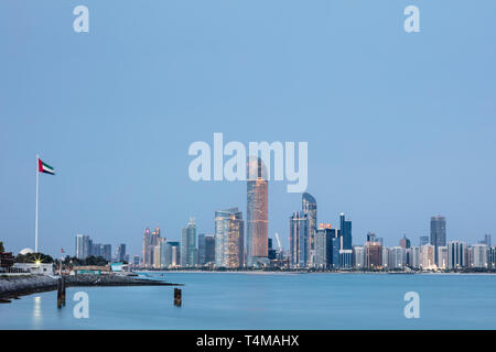 ABU DHABI, VEREINIGTE ARABISCHE EMIRATE - 7. April 2019: Die Stadt von Abu Dhabi in der Abenddämmerung über dem Arabischen Golf gesehen. (Ryan Carter) Stockfoto