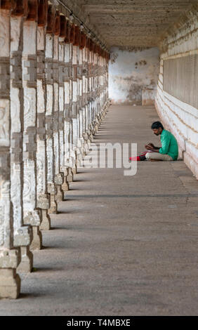 Vertikale Ansicht von einen Mann auf dem Boden an der Thillai Nataraja Tempel in Chidambaram, Indien sitzen. Stockfoto