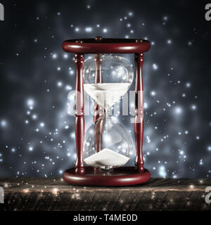 Vintage Sanduhr am Holztisch mit funkelnden blauen Bokeh Hintergrund-Konzept Stockfoto