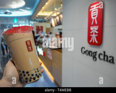 März 2019 - Südkorea: Kaukasisch weiblich Hand mit einem Jumbo Größe schwarze Milch Kaffee mit Perlen oder Bubble Tea von der Taiwanesischen Marke Gong Cha Stockfoto