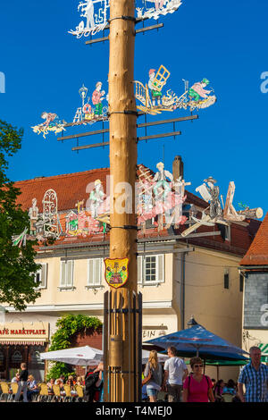 Toller Blick auf einen Maibaum oder Maibaum, eine große hölzerne Stange errichtet auf dem Marktplatz in Seligenstadt, Deutschland. Der Pol ist mit... Stockfoto