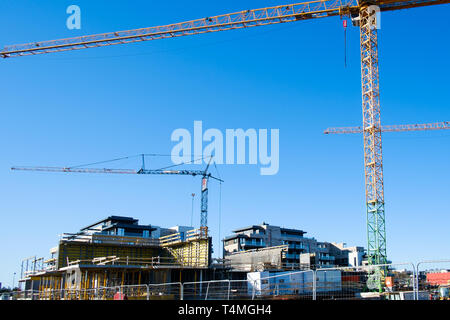 Baustelle mit Kränen gegen blauen Himmel Stockfoto