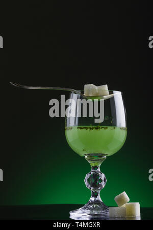 Glas Absinth mit Löffel und Klumpen Zucker Stockfoto