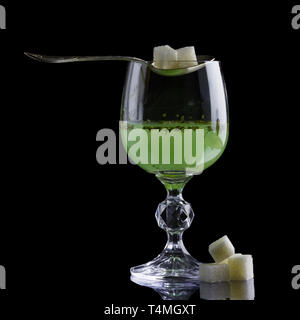 Absinth Glas mit Klumpen Zucker Stockfoto