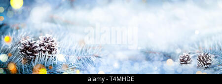 Weihnachtsdekoration Banner - verschneite Tannenzapfen auf Fichte Zweig mit Beleuchtung Stockfoto