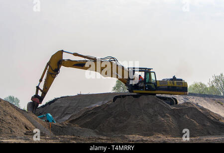 Bagger laden Sand im Fahrzeug auf den Bau von Zufahrtsstraßen für die Brücke Stockfoto