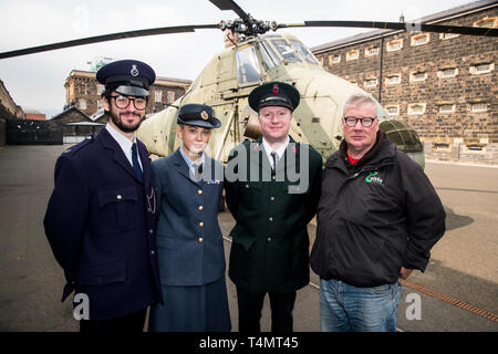 (Von links nach rechts) Aaron Hickland, Niamh Lowry, David Porter aus dem Crumlin Road Gaol und Cioste-Tourguide Peader Whelan, der vor einem stillgelegten Westland Wessex XR 529 ÔECHO' Hubschrauber steht, der im Crumlin Road Gaol in Belfast ausgestellt ist und Teil einer neuen Thementour zum Thema Probleme ist. Stockfoto