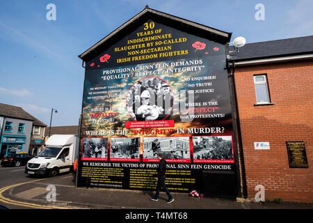 Ein Mann hinter einem Wandbild an der Shankill Road das Erinnern an die Opfer, die in der protestantischen Gemeinschaft während der Mühen, die ist ein Teil der neuen Mühen themed Tour enthalten. Stockfoto