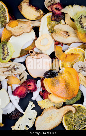 Vielen varietty Frucht Chips auf schwarzem Hintergrund sind verstreut, Konzept der gesunden und richtigen Ernährung, Snack, Ansicht von oben, kopieren Raum Stockfoto