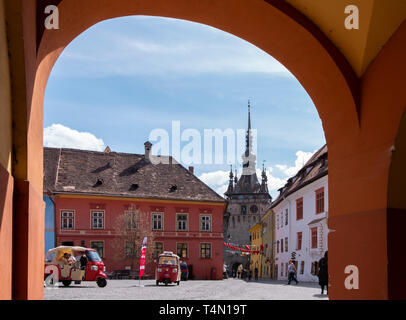 Alba Iulia, Rumänien - 9. April 2019: Der Uhrturm in Sighisoara, durch die Bögen am Eingang in die Zitadelle Square an einem sonnigen Tag gesehen in Stockfoto