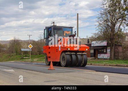 Kamennomostsky, Russland - 13 April, 2019: Asphalt Walze Walze rollt neue Asphalt auf der Autobahn im Dorf Stockfoto