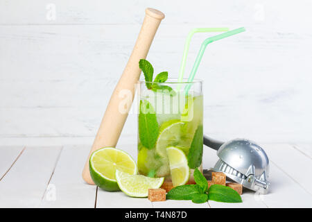 Mojito Cocktail auf Holztisch mit Limette, Minze, Zucker, muddler und Ice Crusher Stockfoto