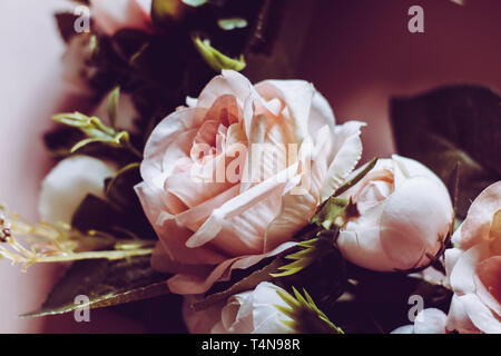 Nahaufnahme von gefälschten rosa Rose Wreath auf einem rosa Hintergrund mit gefälschten Blätter - perfekte Hochzeit, Beerdigung, Geburtstag, besonderen Anlass Card oder laden Stockfoto